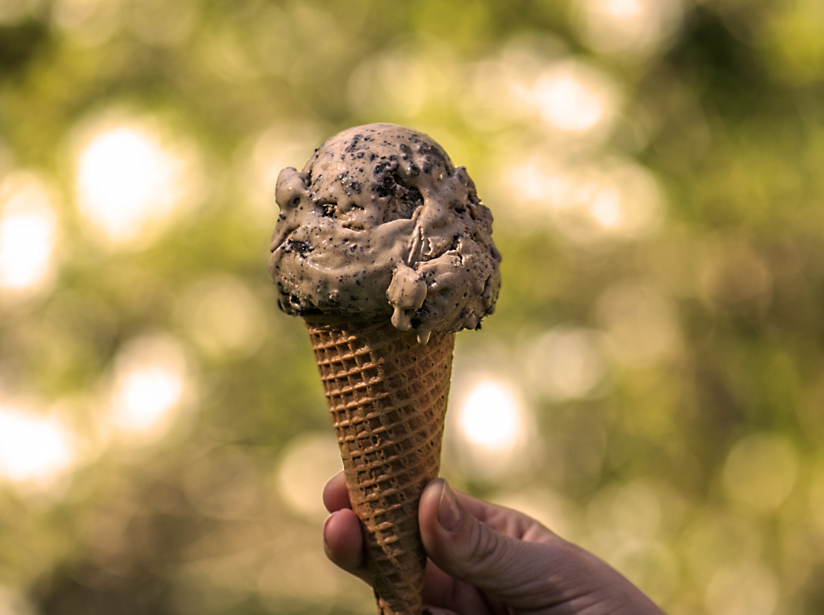 Coffee crunch ice cream cone held outdoors